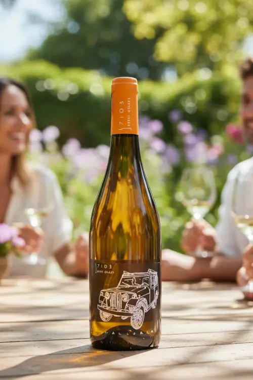 Giro Jove Weinflasche auf einem Gartentisch. Personen im Hintergrund